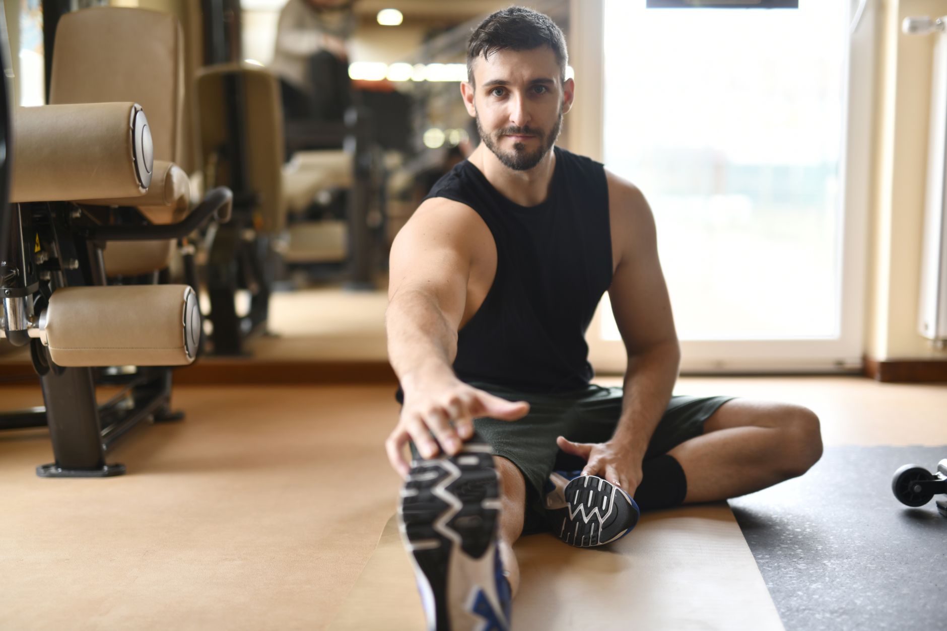 man in black tank top stretching